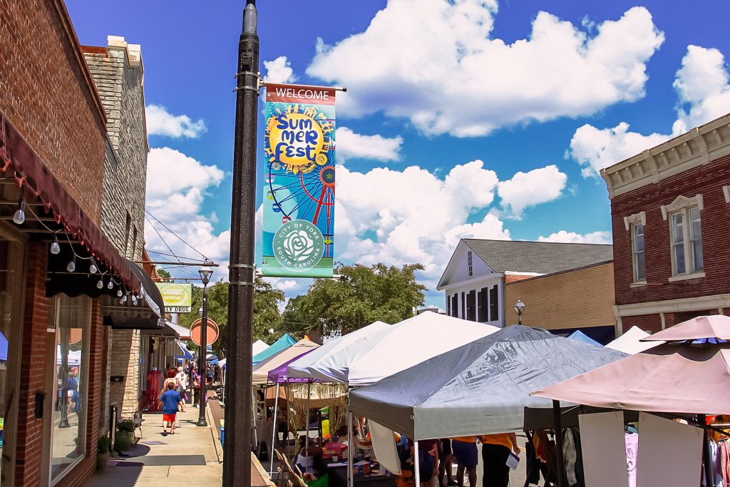 Summerfest in York, South Carolina: Music, Food, and Family Fun Vendor tents line Main Street during York Summerfest, with shoppers browsing under a sunny sky in downtown York, SC.