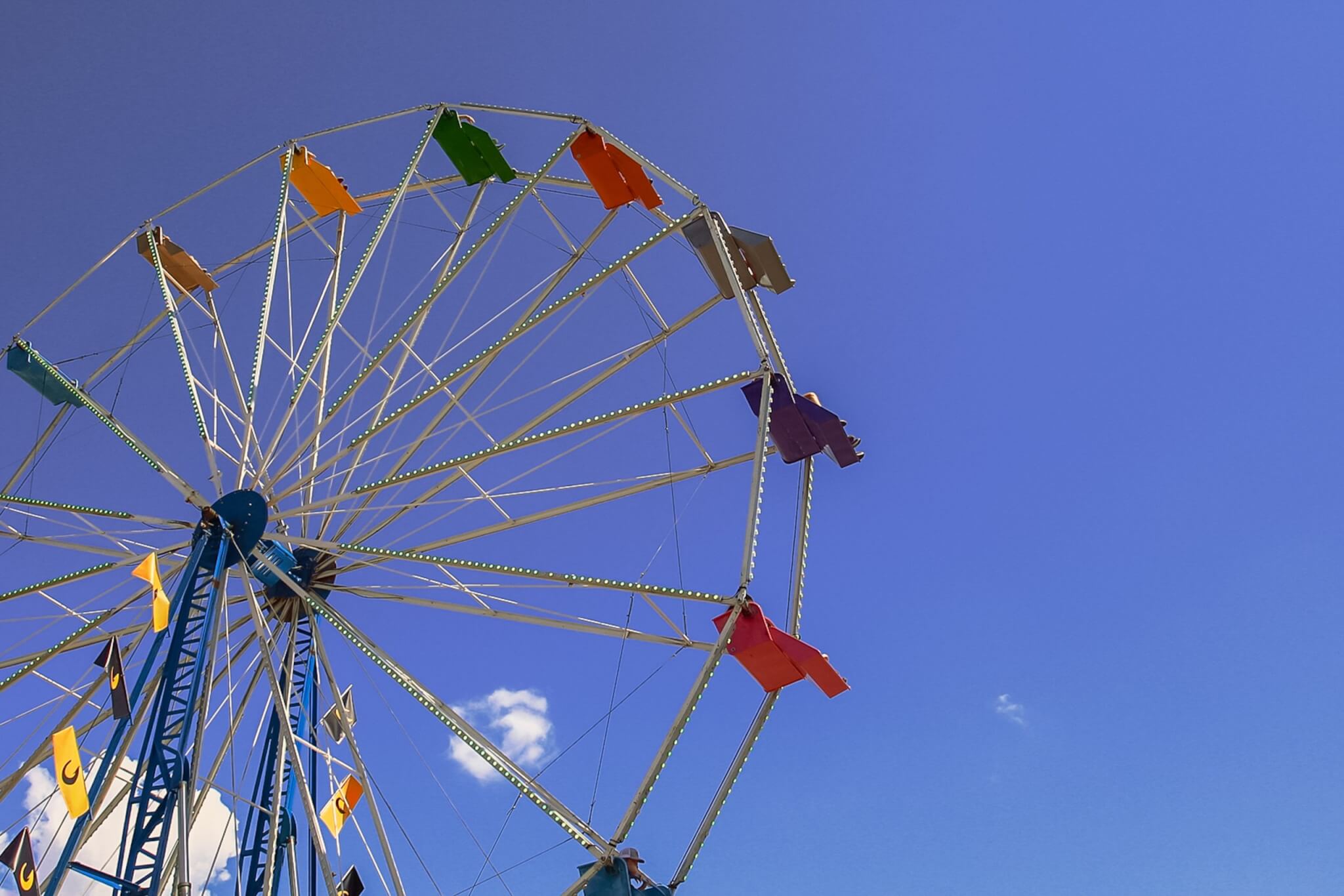 Summerfest in York, South Carolina: Music, Food, and Family Fun Colorful Ferris wheel at York Summerfest against a bright blue sky, with South Carolina flags along the ride’s frame.