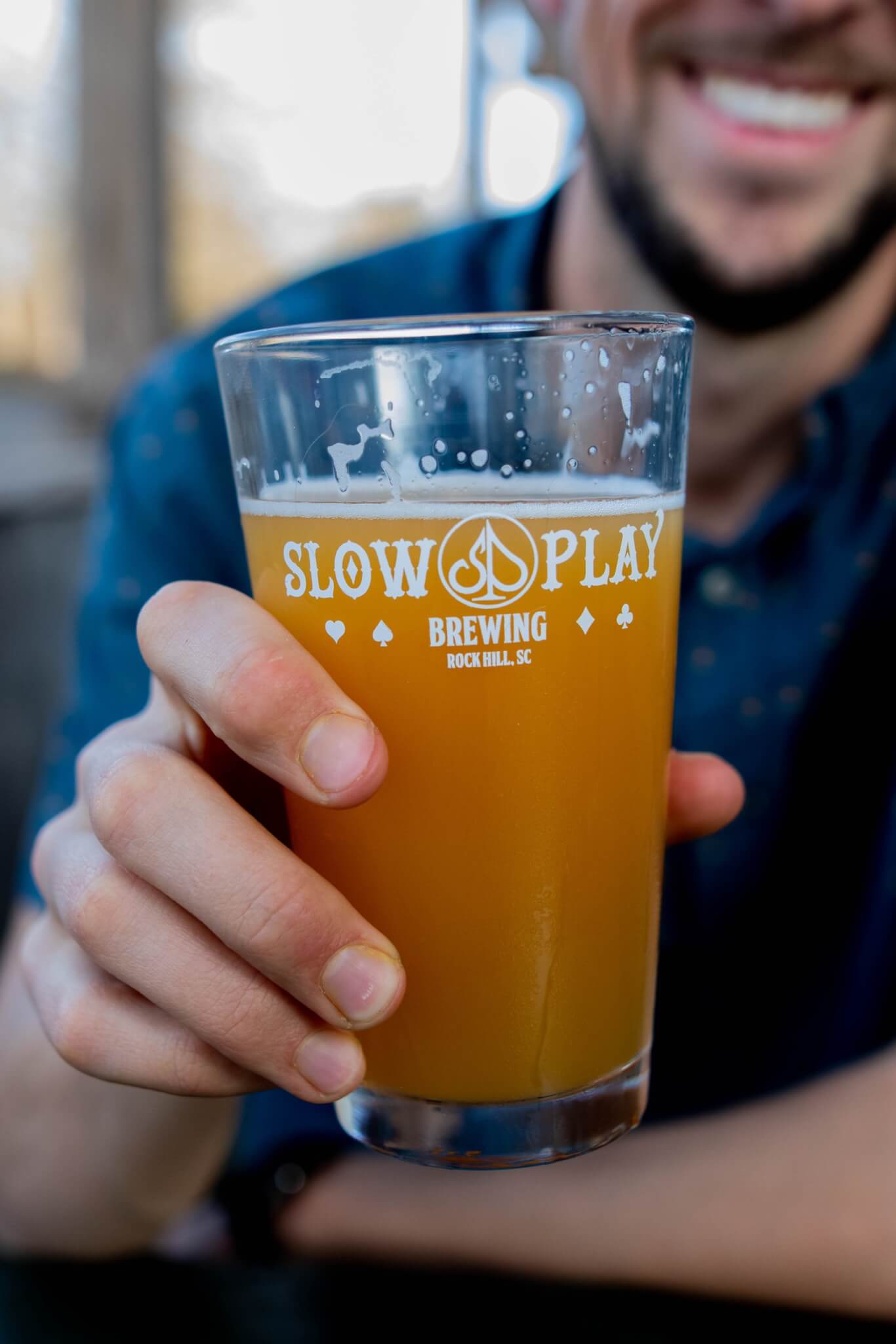 holding beer at Slow Play Brewing