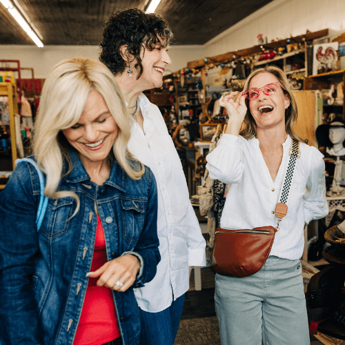 Three women laughing and shopping