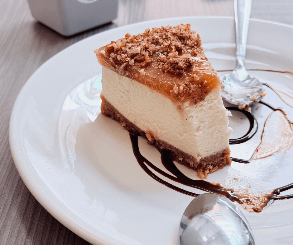 Must Try Sweet Treats in The Olde English District A slice of creme brulee cheesecake on a plate with spoons